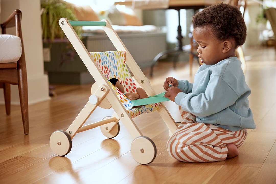 Child playing with The Buddy Stroller by Lovevery