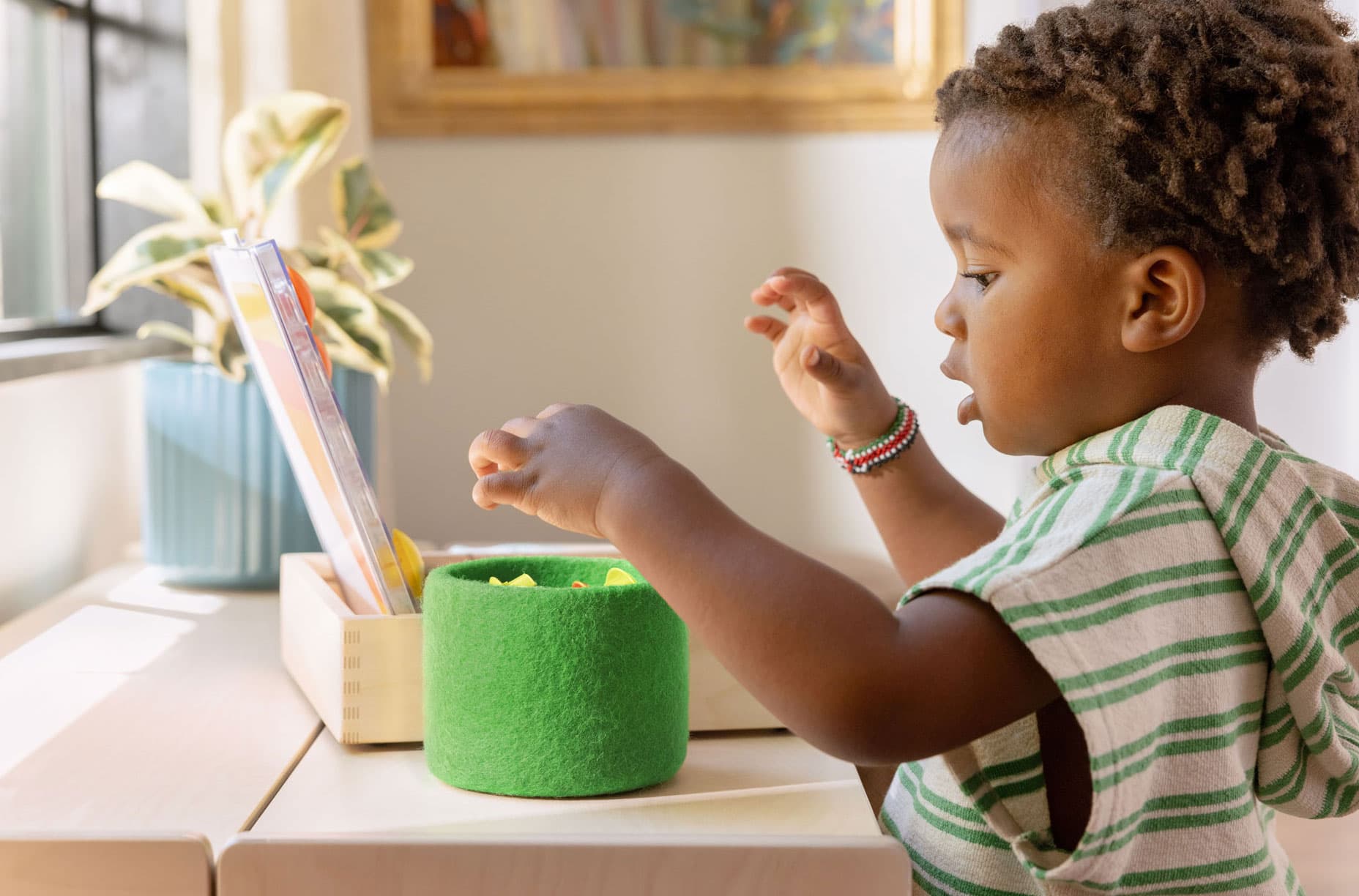 Boy using the Basket to hold Lovevery toys