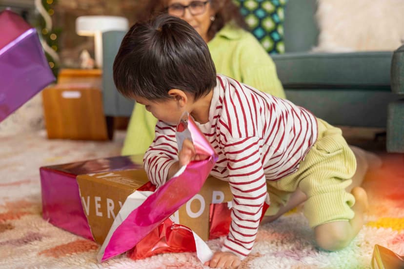 Boy opening a wrapped gift from Lovevery